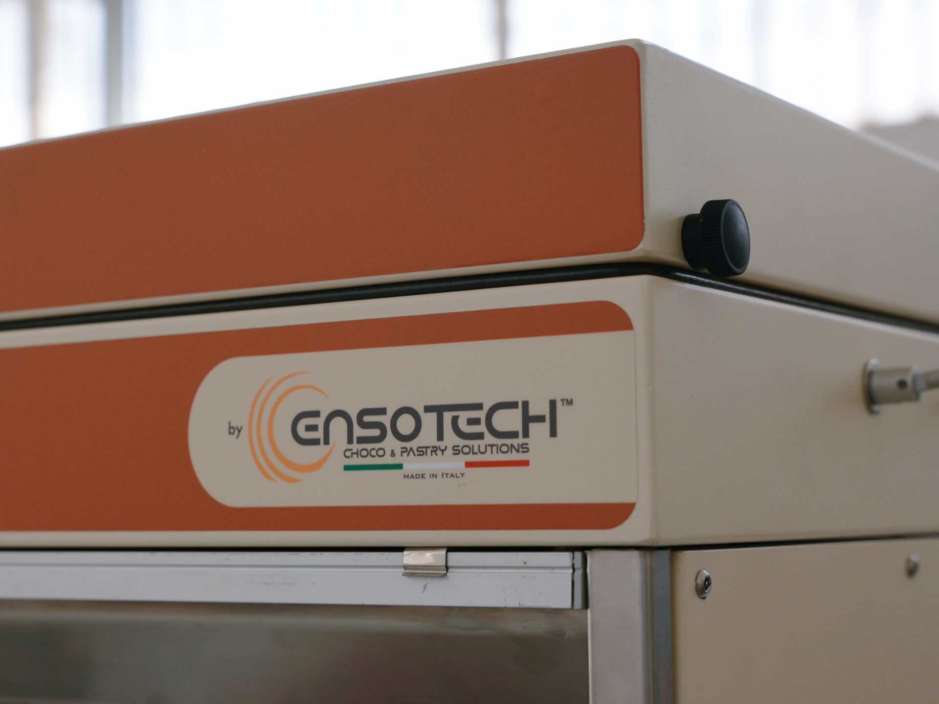 Logo Ensotech sull’angolo di una cabina di aspirazione per pasticceria e cioccolato