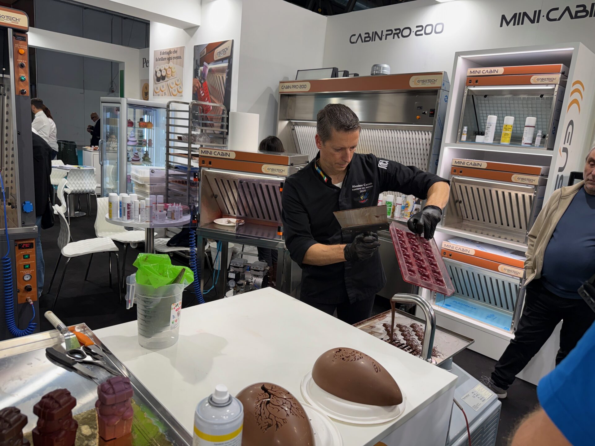 Massimo Carnio allo stand Ensotech a HOST Milano mentre utilizza le cabine di aspirazione per pasticceria e cioccolato