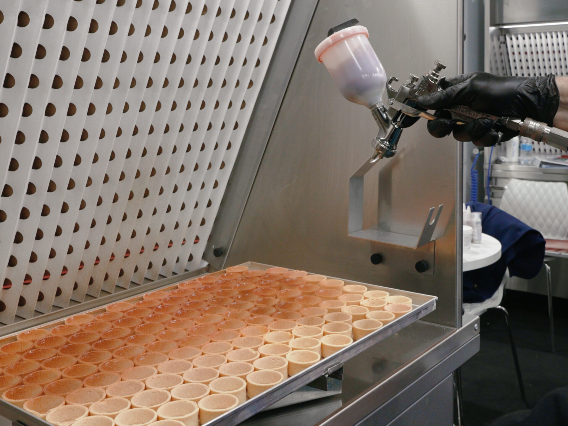 Cabina di aspirazione per cioccolato e pasticceria All-In-One Ensotech in uso con aerografo