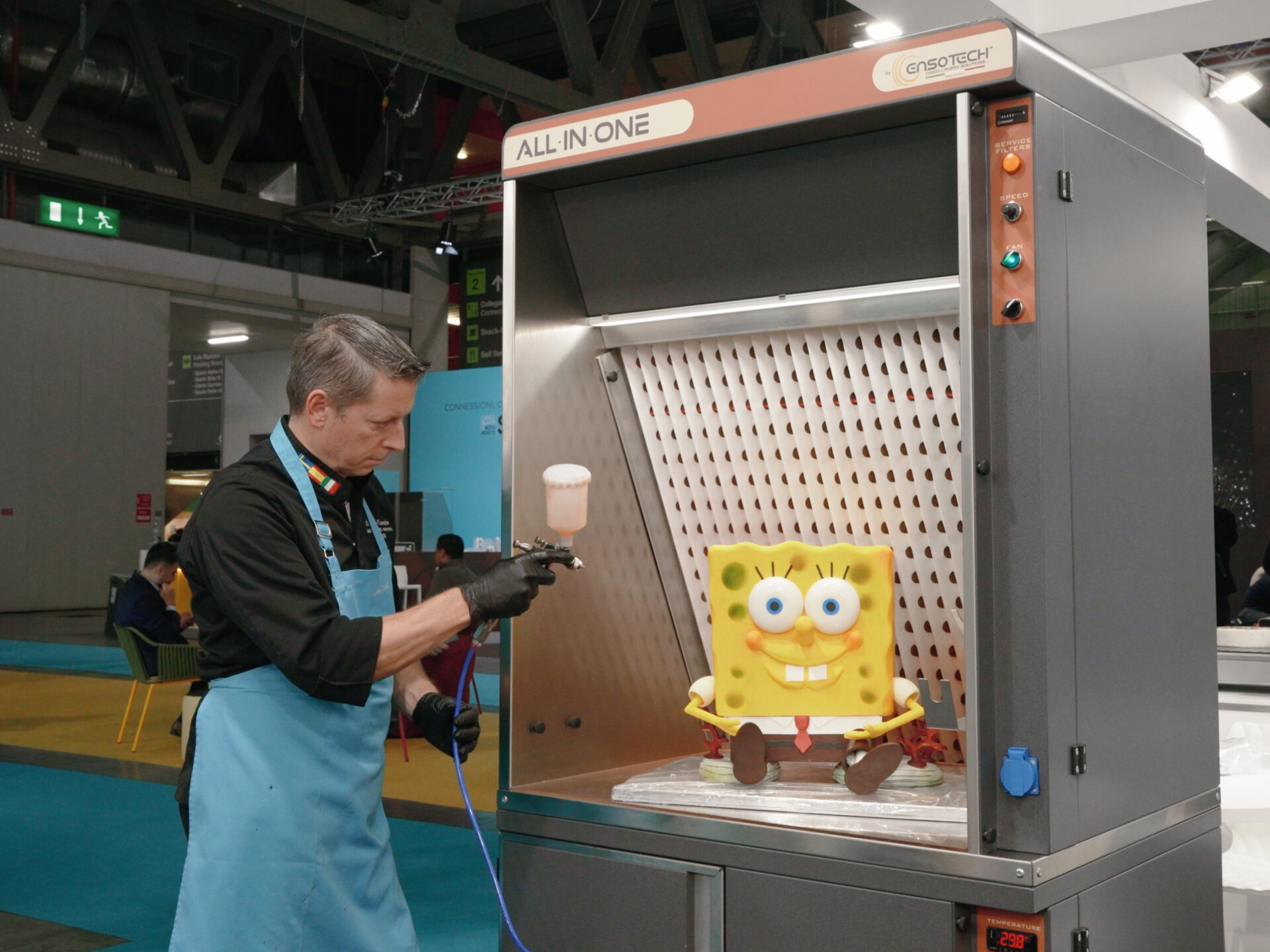 Massimo Carnio decora SpongeBob con aerografo nella cabina All-In-One Ensotech aspirazione cioccolato